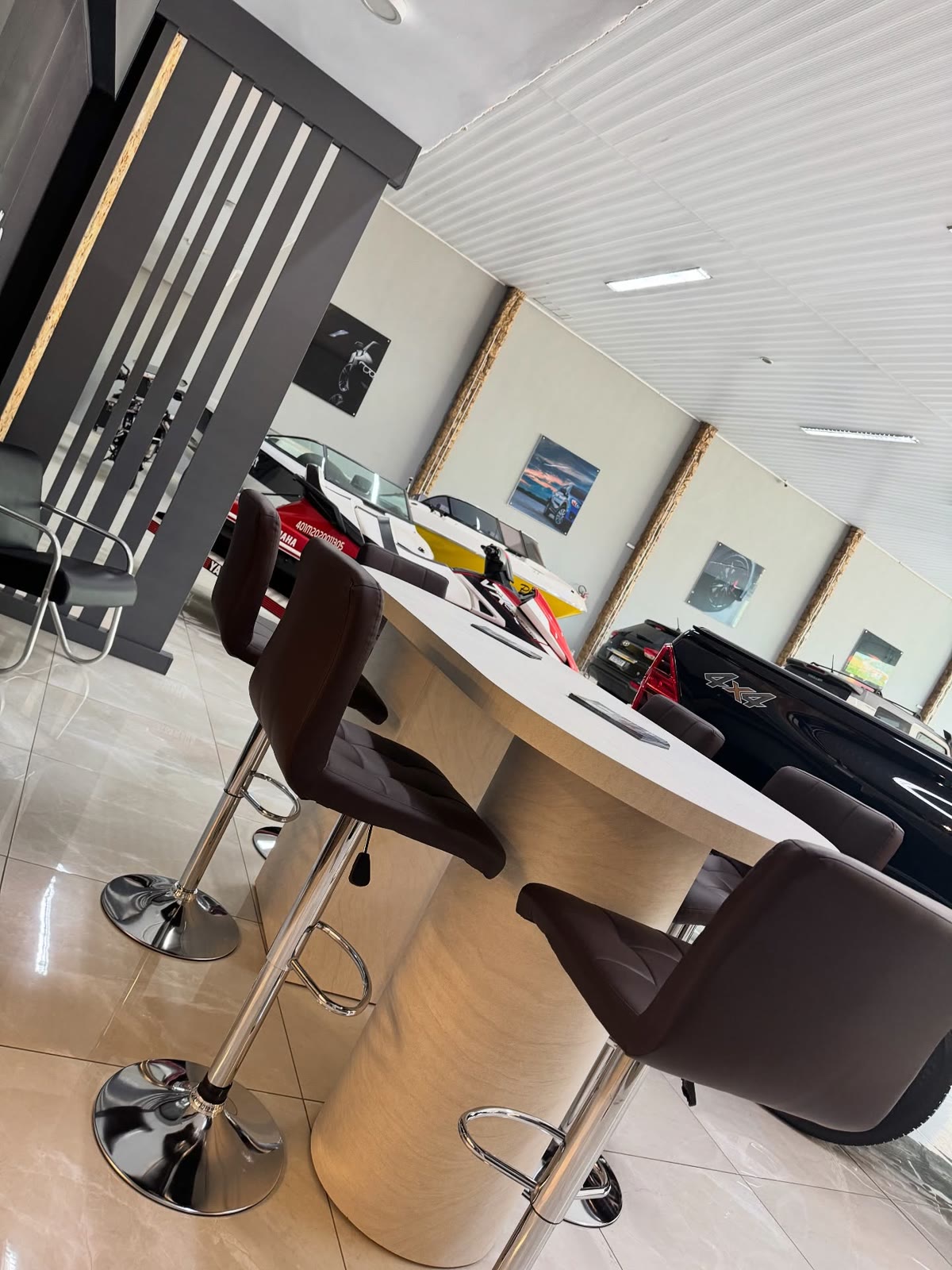 Showroom automotivo com mesa alta e painéis planejados